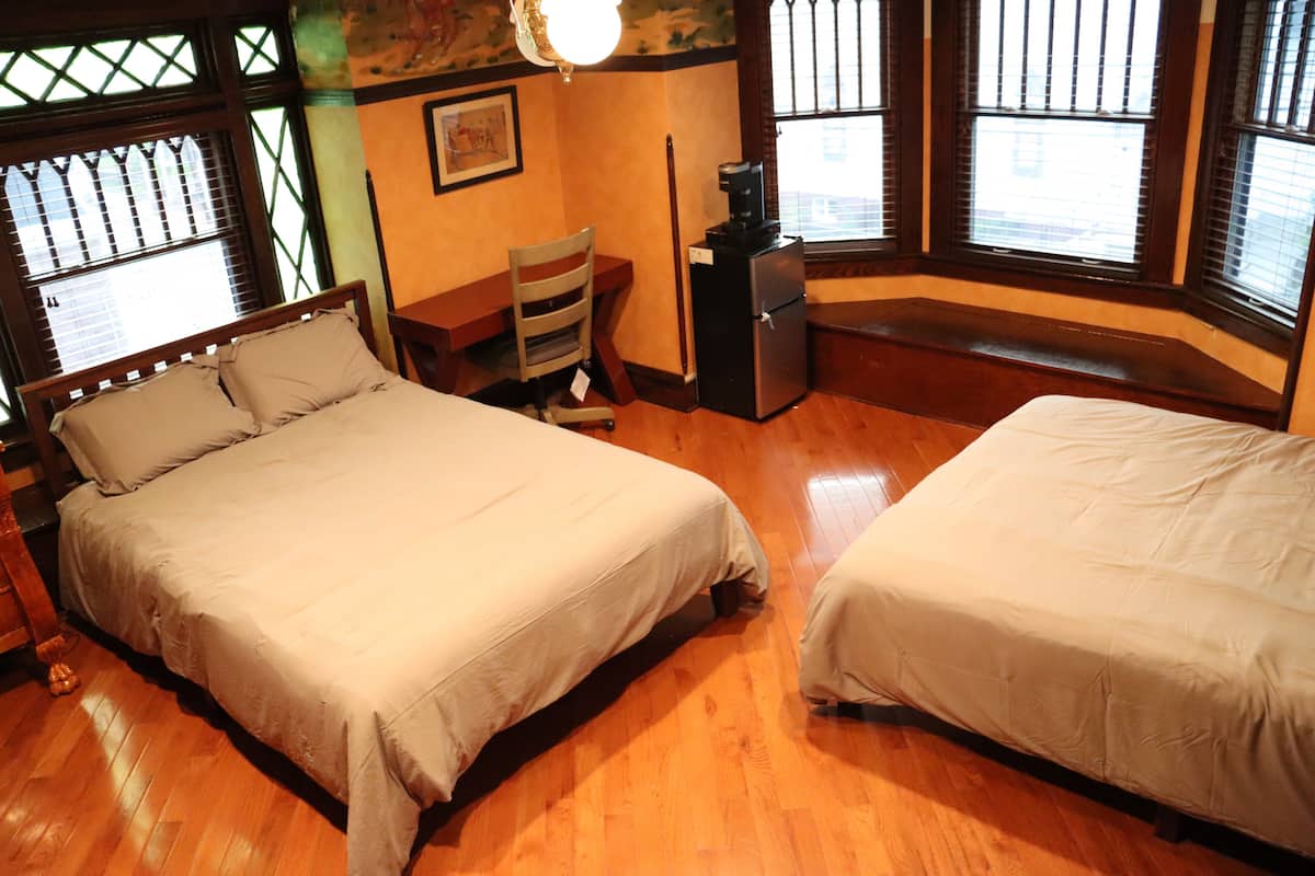 Une chambre avec deux lits, un bureau et une chaise.