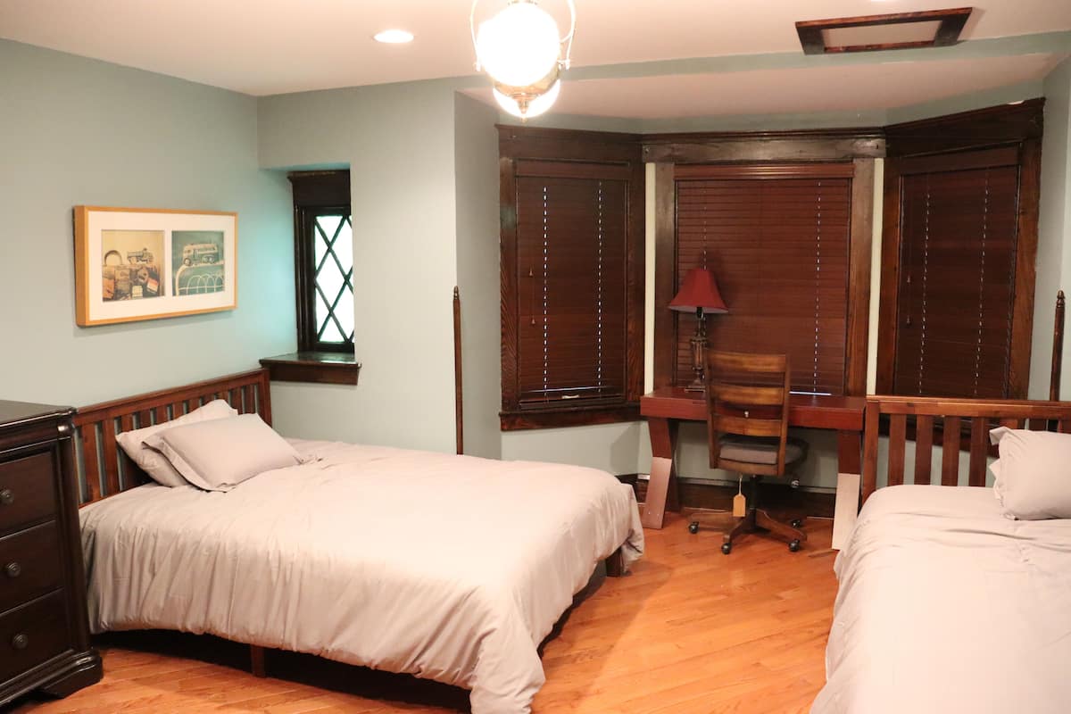 Une chambre avec deux lits, un bureau et une chaise.