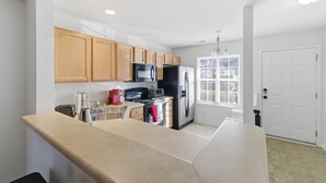 A modern kitchen with wooden cabinets, stainless steel appliances, and a large countertop. - Spacious 2 bedrooms townhouse by the Greenway/ Pool access (Raleigh)