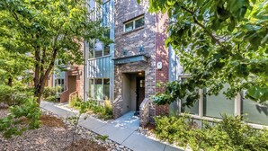 A modern building with a brick facade, large windows, and a well-maintained garden area. - Post-Worthy Rooftop Views / Super Walkable LoHi Area / Modern 3b3b (Denver)