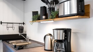 Una cocina moderna con estufa integrada, cafetera y tostadora sobre la encimera.