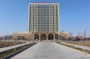 Un edificio grande de varios pisos con fachada plana y una entrada central.