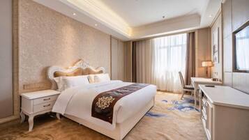 A hotel room with a large bed, a desk, and a chair.