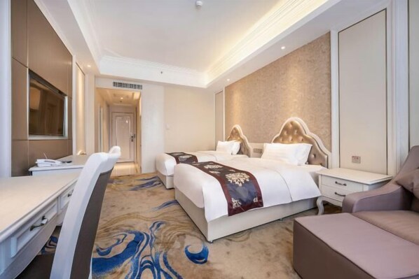 Una habitación de hotel con una cama, un escritorio, una silla y una televisión.