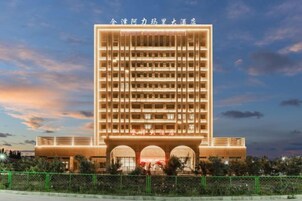 Un hotel de varios pisos con una entrada destacada y un letrero grande en la parte superior.