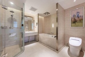 Un baño moderno con ducha de vidrio, bañera independiente y un inodoro.