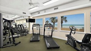Uma academia com esteiras, bicicletas ergométricas e aparelhos de musculação.
