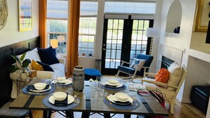 A dining area with a table set for four, a sofa, and a chair.