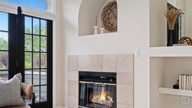 A living room with a fireplace, a sofa, and a large window.