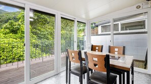 A room with a table and chairs, large windows, and a view of greenery. - Gapyeong Gamseong216 Poolvilla Pension (Gapyeong)