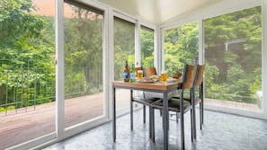 A dining area with a table set for two, large windows, and a view of greenery. - Gapyeong Gamseong216 Poolvilla Pension (Gapyeong)
