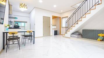 Ein modernes Interieur mit Küche, Essbereich und Treppe.