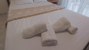 A neatly made bed with a patterned throw and two rolled towels. - Kallithea - Apartment - Stay 2 - Parking - Seaside (Kallithea)