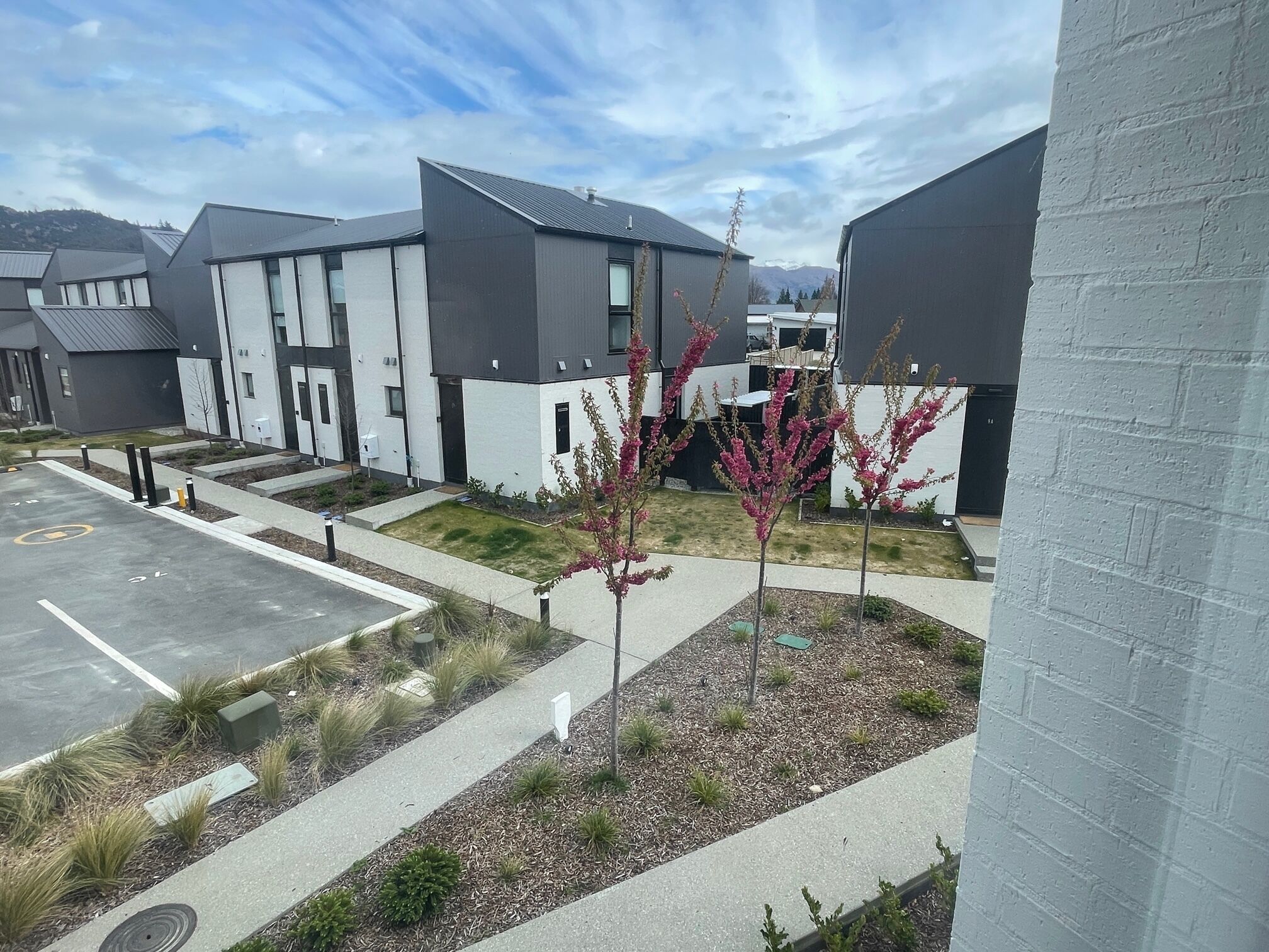 A modern building with a parking lot and landscaped areas.