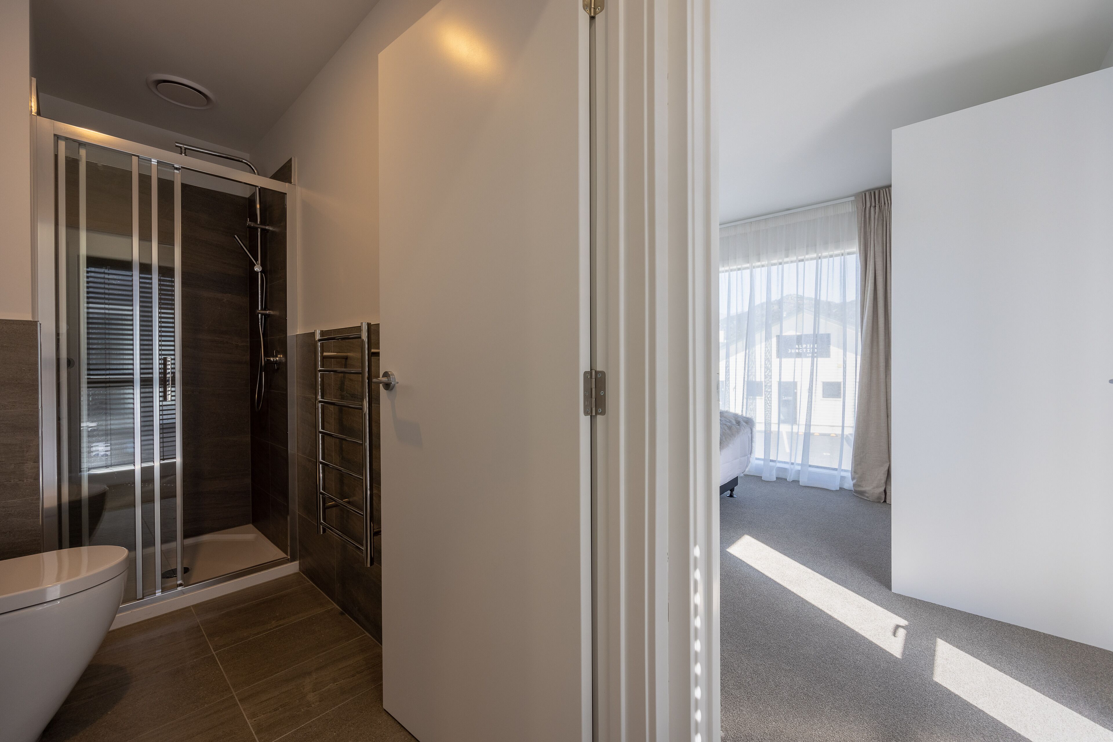 A modern bathroom with a glass shower enclosure, a toilet, and a walk-in shower.