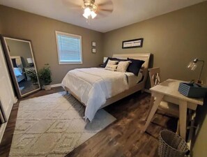 A bedroom with a bed, a desk, a chair, a mirror, a window with blinds, and a ceiling fan. - Beautiful View and Great Location 1mile from I24 (Chattanooga)