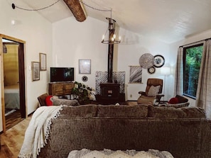 Ein gemütliches Wohnzimmer mit einer großen Couch, einem Fernseher, einem Kamin und einem Essbereich.