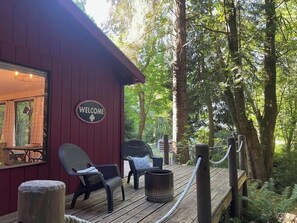 A wooden deck with two wicker chairs and a welcome sign. - Forested Cottage in the Woods, near Olympic Park (Port Angeles)