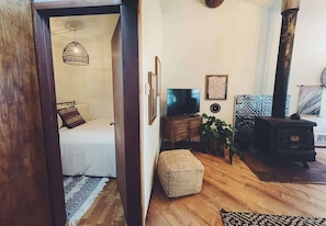 Ein gemütliches Wohnzimmer mit Sofa, Hocker und Kamin.