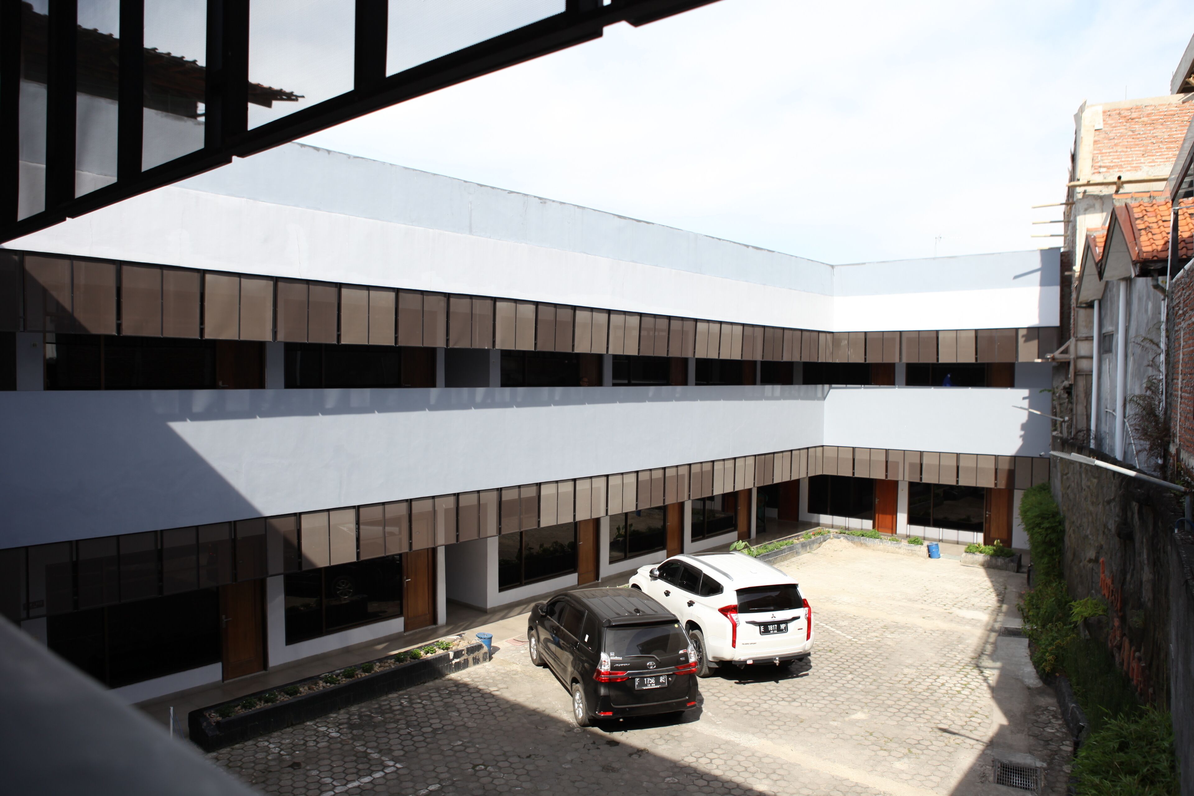 A multi-story parking structure with two cars parked in the foreground.