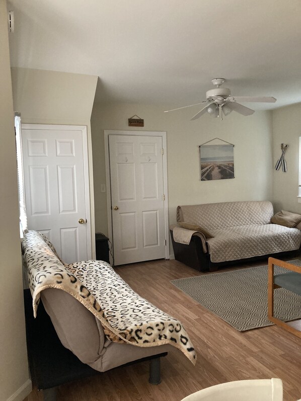 A room with a bed, a sofa, a ceiling fan, and a door. - 4.5 blocks to beach. Huge yard (Wildwood)