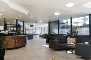 Welcome to our reception area, featuring a reception desk, comfortable seating, and a large window offering a view of the outdoors.