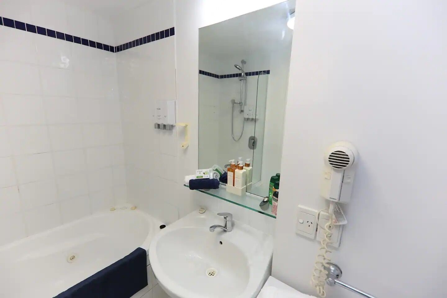 Un baño con bañera, lavabo y espejo.