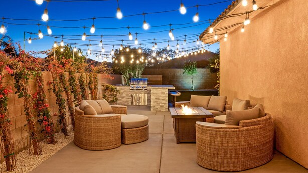 Eine Terrassengaststätte mit Korbmöbeln, einer Bar und Lichterketten.