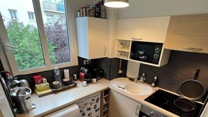Una cucina funzionale con lavatrice, lavello, fornello e microonde.