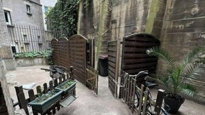 Un cortile con una panchina, una bicicletta e una pianta in vaso.