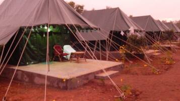A row of tents with a flat platform and seating area.