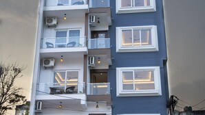 A multi-story building with balconies, air conditioning units, and a spa sign. - Hotel Dream Inn (Narendranagar)