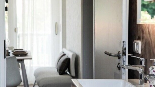 Une salle de bain moderne avec un lavabo blanc, un miroir et un espace douche.