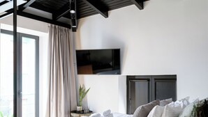 A modern bedroom with a large bed, a TV mounted on the wall, and a balcony with curtains. - Mamy Blue Slow Living (Athens)