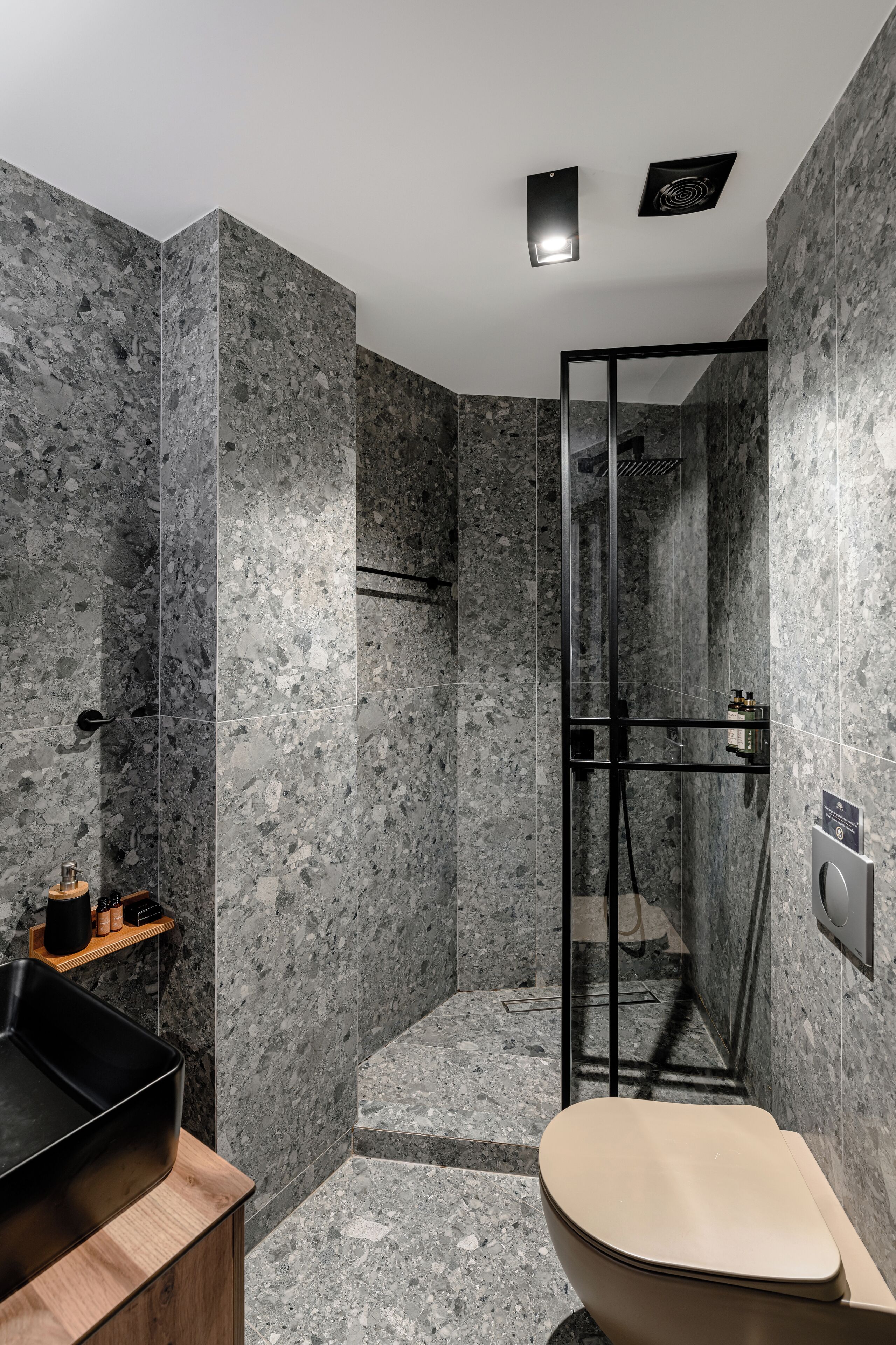 A modern bathroom with a shower, toilet, and sink.