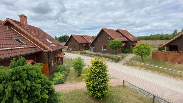 Ein Wohngebiet mit mehreren Häusern, die Satteldächer und Holzbauten aufweisen.