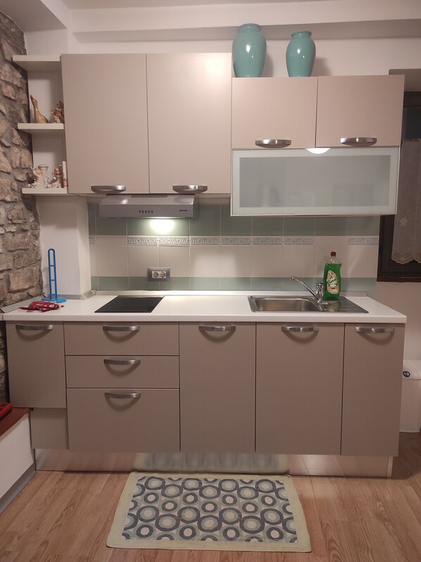 Una cocina moderna con una isla central, electrodomésticos de acero inoxidable y un salpicadero con azulejos decorativos.