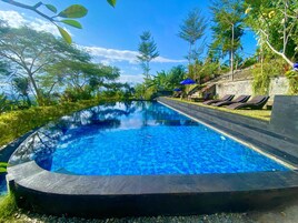 Una piscina al aire libre, sillones reclinables de piscina