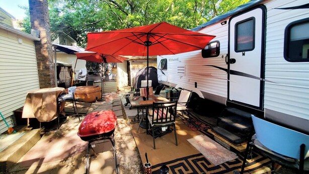 A covered outdoor patio with a barbecue, seating, and a large red umbrella. - Room-fall Room 3min From Yale, And Other (New Haven)