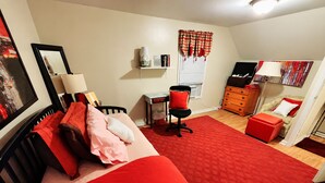 A bedroom with a red carpet, a bed with red and pink bedding, a desk with a chair, a dresser, and a window with curtains. - Room-fall Room 3min From Yale, And Other (New Haven)