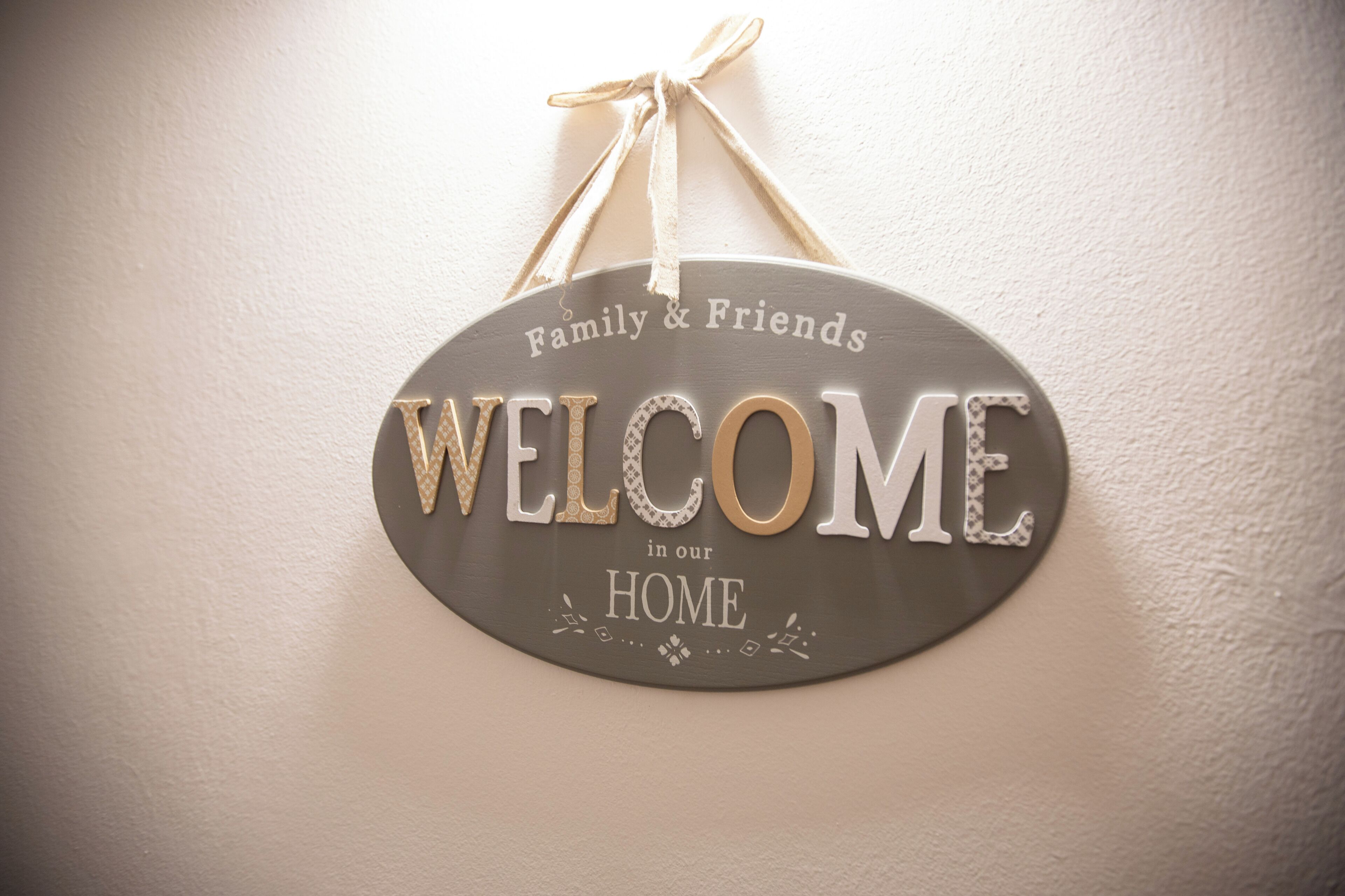 Un letrero de bienvenida con el texto 'Familiares y amigos bienvenidos en nuestro hogar'.