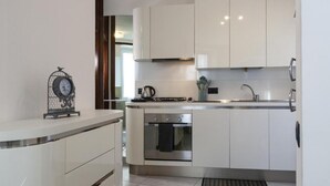 Een moderne keuken met witte kasten, roestvrijstalen apparatuur en een inbouwoven.