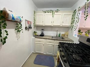 Apartament, 3 dormitoris, fumadors, pati | Cuina privada | Placa de cuina, cafetera i tetera, trona i una taula de menjador