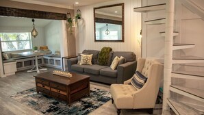 A modern living room with a grey sofa, a white armchair, a wooden coffee table, and a blue patterned rug. - Family Home With Private Pool & Yard Only 24 Mi to Disney (St. Cloud)