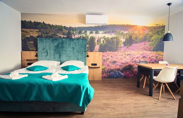 A bedroom with a bed, a desk, and a chair.