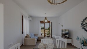 A modern living room with a sofa, coffee table, TV, and decorative items.