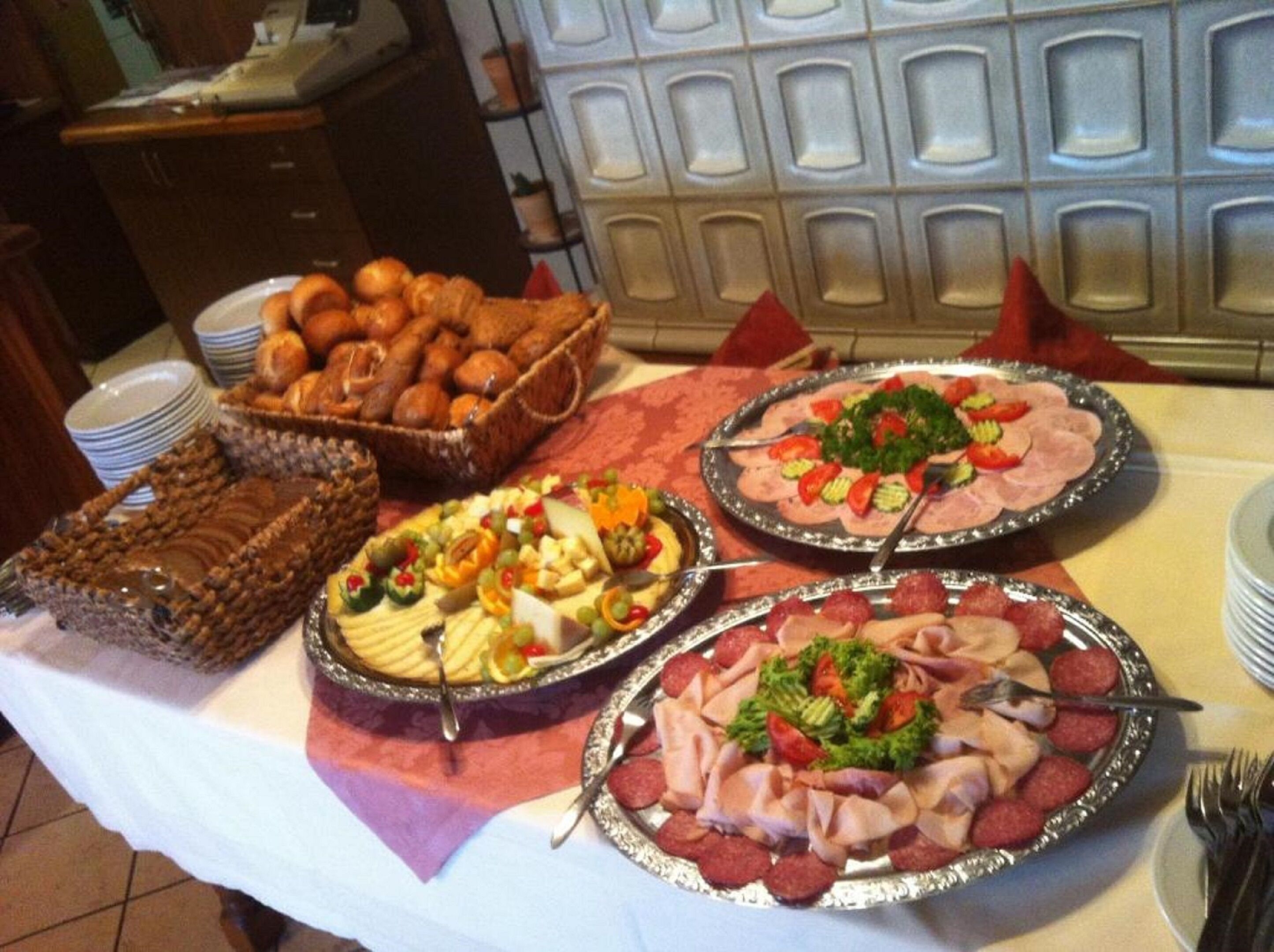 Een buffettafel met diverse gerechten, zoals vleeswaren, kazen en gebak.