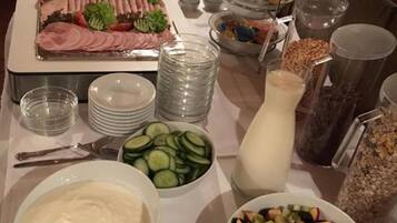 A buffet table with various food items including sliced meats, salads, and fruits.