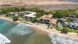 Un hôtel situé sur la côte, composé de plusieurs bâtiments, doté d’une piscine et donnant accès à une plage.
