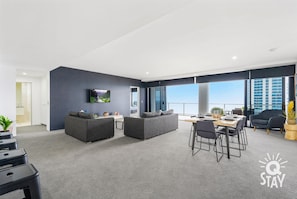 Relax in this stylish living area with a sofa, dining table, and city view.